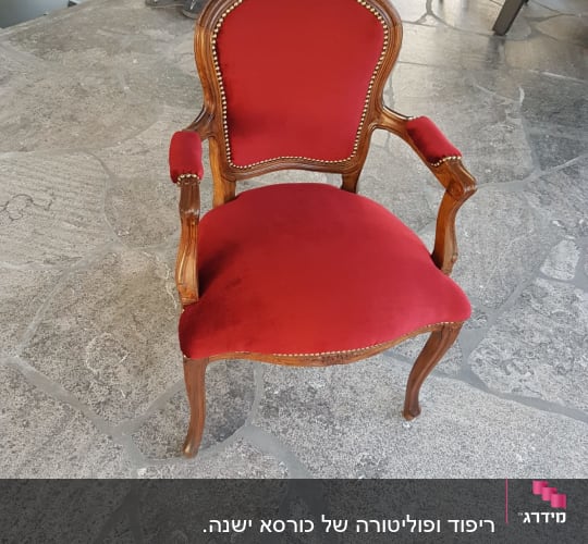 כיסא עץ מרופד בבד אדום עם מסמרים דקורטיביים